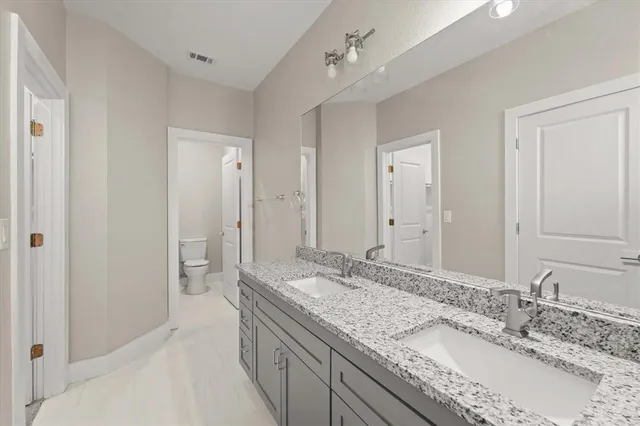 a bathroom with a granite countertop sink mirror and shower