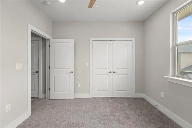 en empty room with windows and ceiling fan