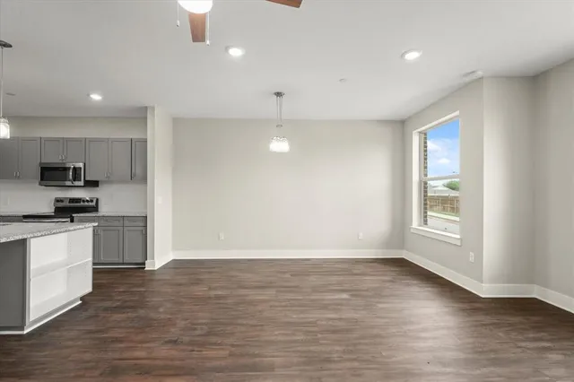 a view of kitchen with kitchen island wooden floor center island and stainless steel appliances
