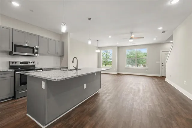 a kitchen with a sink window and wooden floor