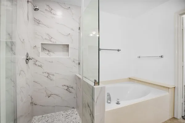 a bathroom with a granite countertop sink a mirror and a bathtub