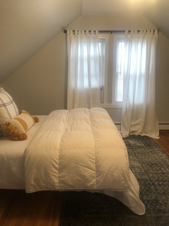 16-18 Kimball Road Watertown, MA 02472 - Photo 35 of 37 a large bedroom with a bed and wooden floor