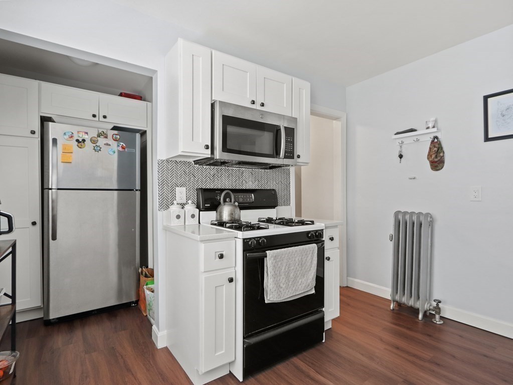 16-18 Kimball Road Watertown, MA 02472 - Photo 7 of 37 a kitchen with stainless steel appliances a refrigerator stove and microwave