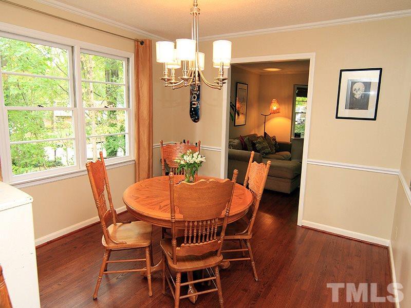 1009 Paddock Drive Raleigh, NC 27609 - Photo 12 of 18 a dining room with furniture a chandelier and wooden floor