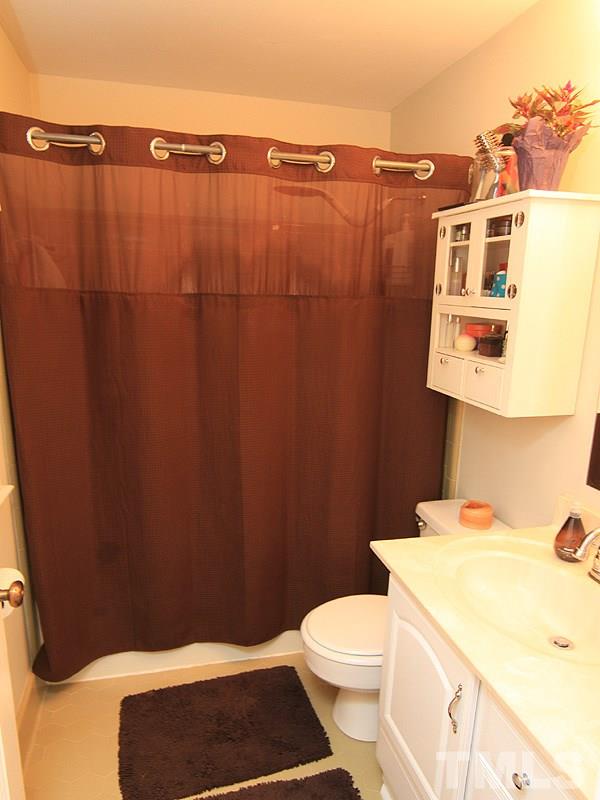 1009 Paddock Drive Raleigh, NC 27609 - Photo 14 of 18 a bathroom with a sink a toilet and shower curtain