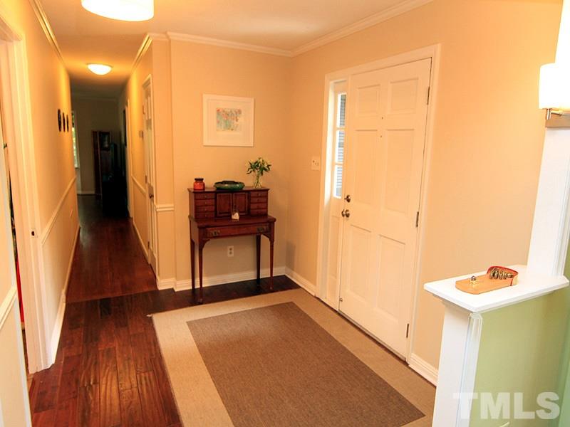 1009 Paddock Drive Raleigh, NC 27609 - Photo 6 of 18 a view of a hallway with wooden floor and a bathroom