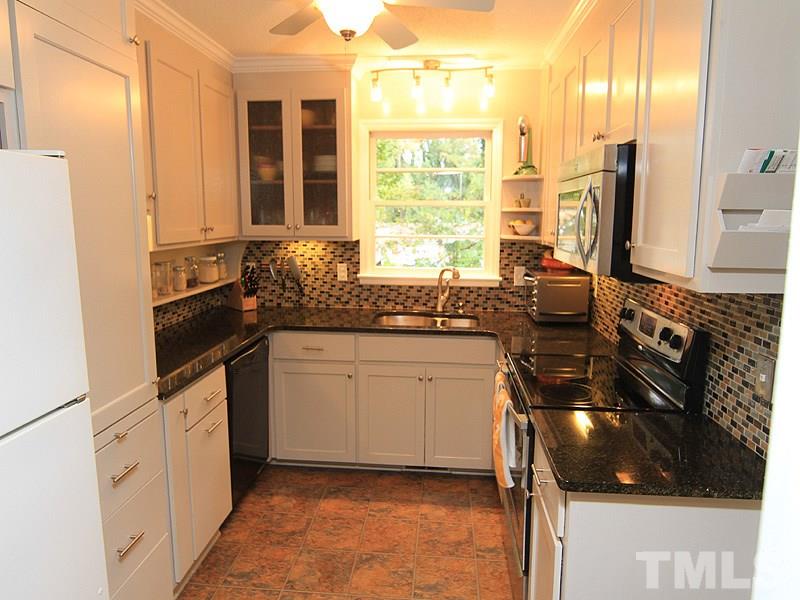1009 Paddock Drive Raleigh, NC 27609 - Photo 7 of 18 a kitchen with a sink stove and cabinets