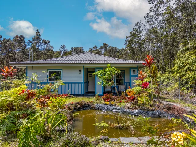 a view of house with garden space and sitting area