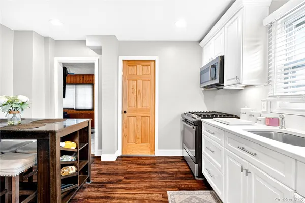 a kitchen with a refrigerator a stove and a wooden floor