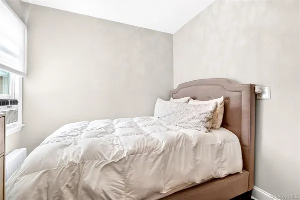 a bedroom with a bed and a window