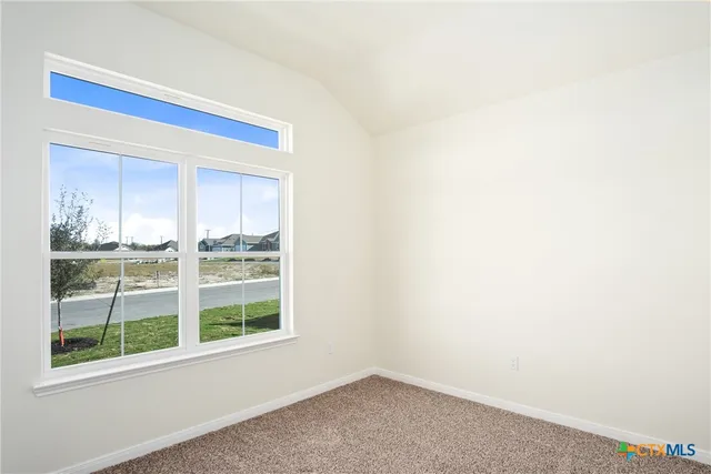 a view of an empty room with closet and a window