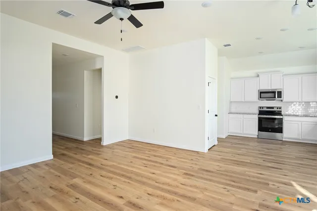 a kitchen with granite countertop white cabinets and white appliances