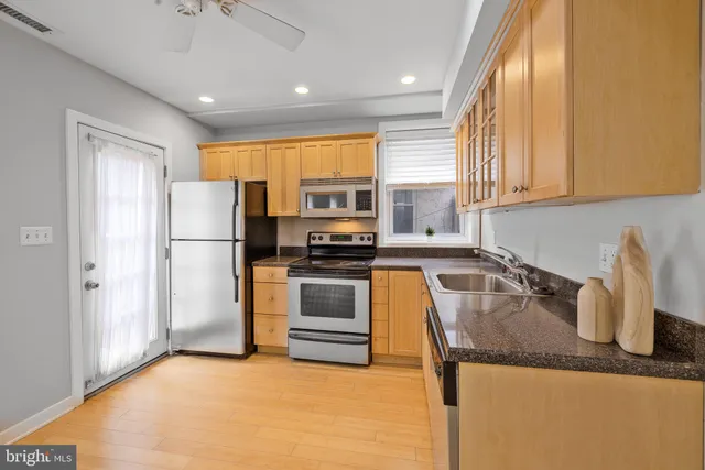 a kitchen with granite countertop a refrigerator and a sink