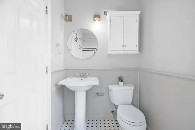 a bathroom with a toilet sink and mirror