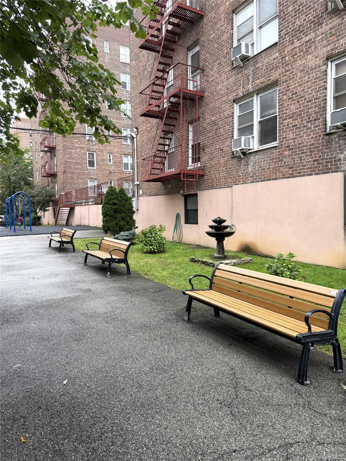 33-25 90th Street, Unit 5D Queens, NY 11372 - Photo 17 of 18 a sitting area with wooden bench sitting in front of a building