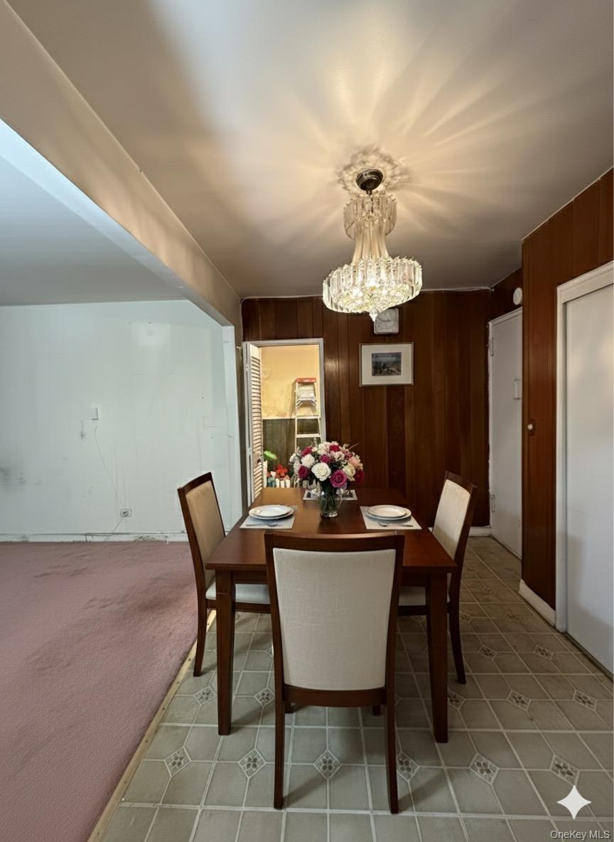 33-25 90th Street, Unit 5D Queens, NY 11372 - Photo 3 of 18 a dining room with furniture a chandelier and a rug