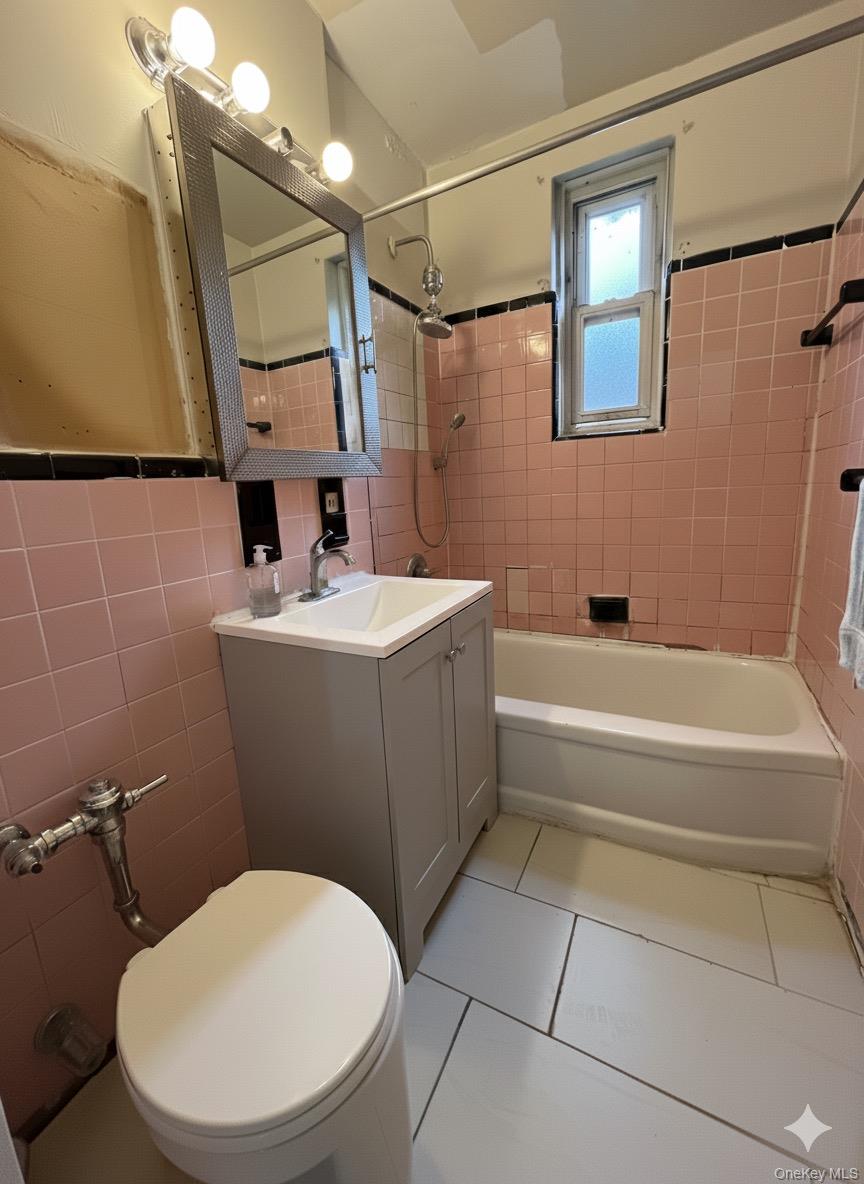 33-25 90th Street, Unit 5D Queens, NY 11372 - Photo 8 of 18 a bathroom with a sink a mirror toilet and bathtub