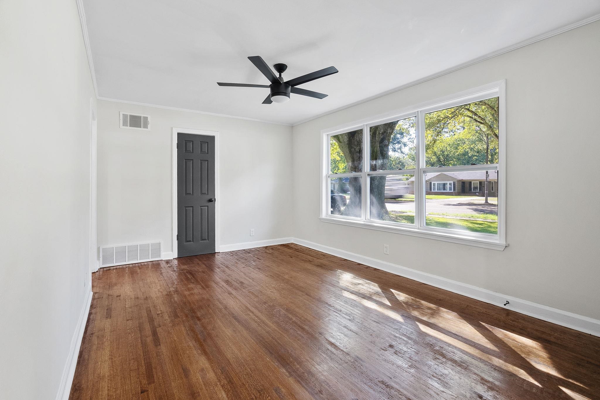 1168 South Perkins Road Memphis, TN 38117 - Photo 7 of 34 a view of an empty room with wooden floor and a window