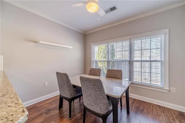 a large kitchen with granite countertop a dining table chairs and wooden floor