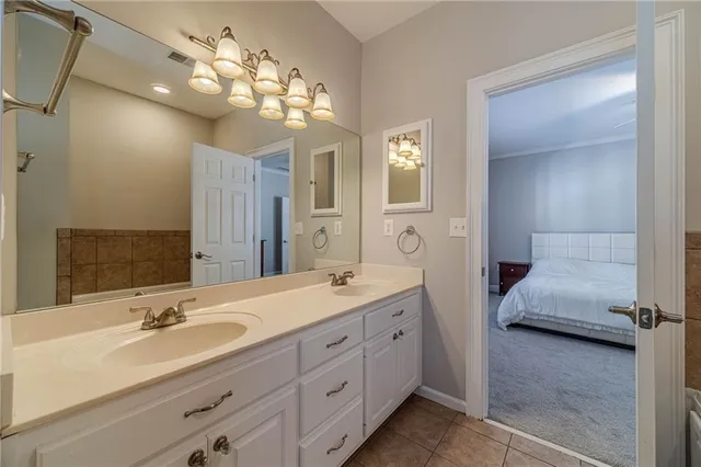 a en suite bathroom with a granite countertop sink mirror and shower