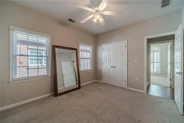 an empty room with closet and a chandelier fan