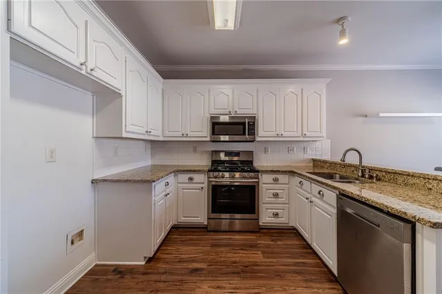 a kitchen with granite countertop white cabinets and white stainless steel appliances
