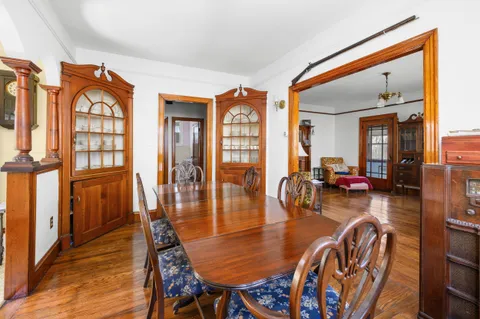 a view of a dining room with furniture a chandelier and wooden floor