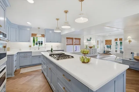 a kitchen with a stove a sink a dining table and chairs