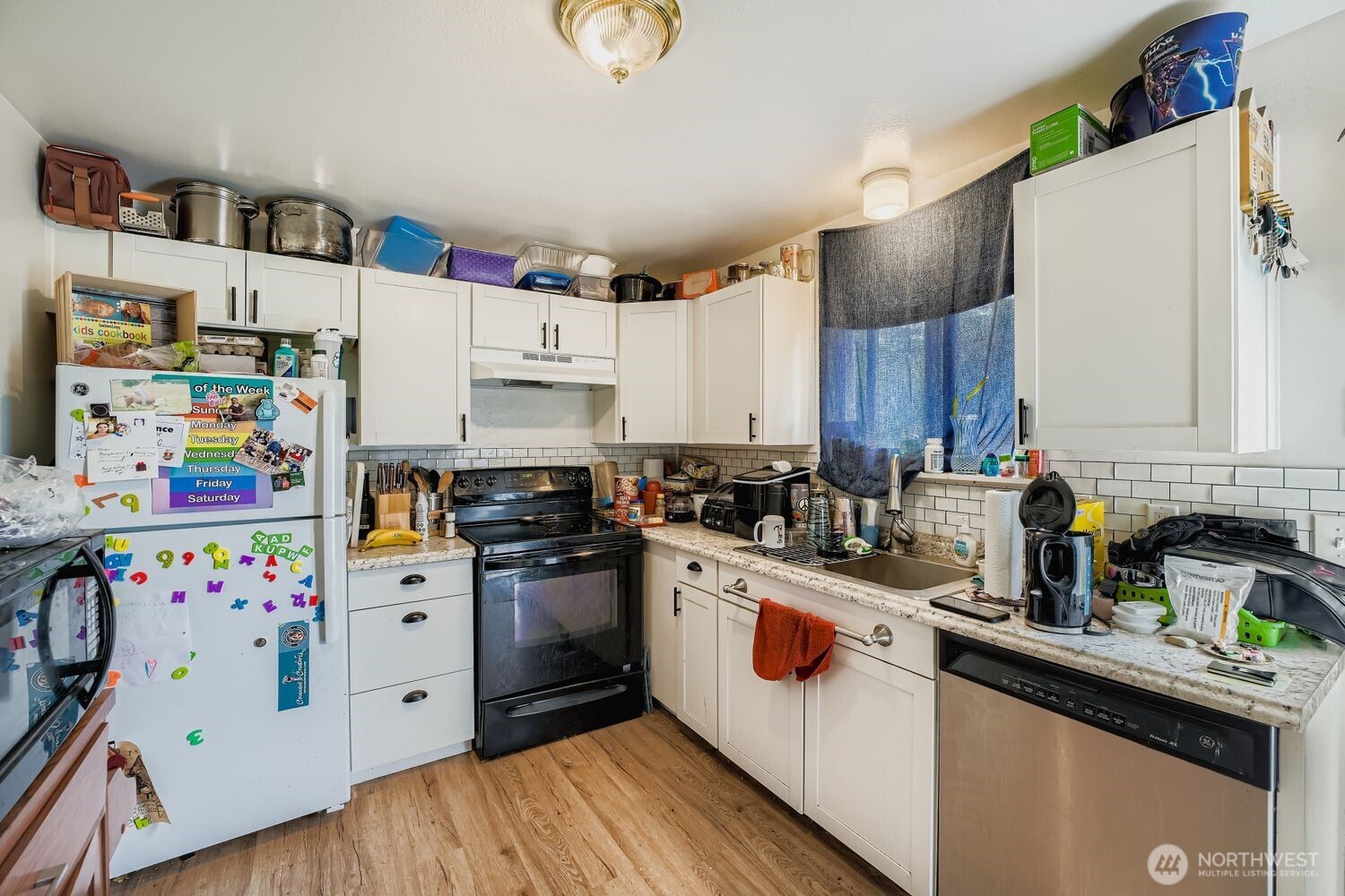 1126 Neil Street Northeast Olympia, WA 98516 - Photo 11 of 21 a kitchen with stainless steel appliances granite countertop a white cabinets sink and a refrigerator