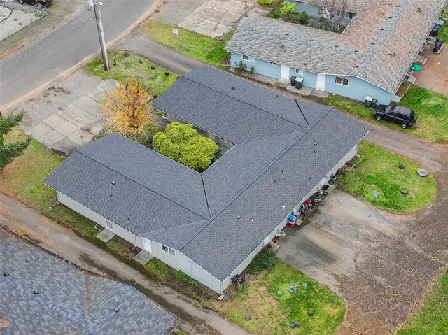 a aerial view of a house with a yard and a bench