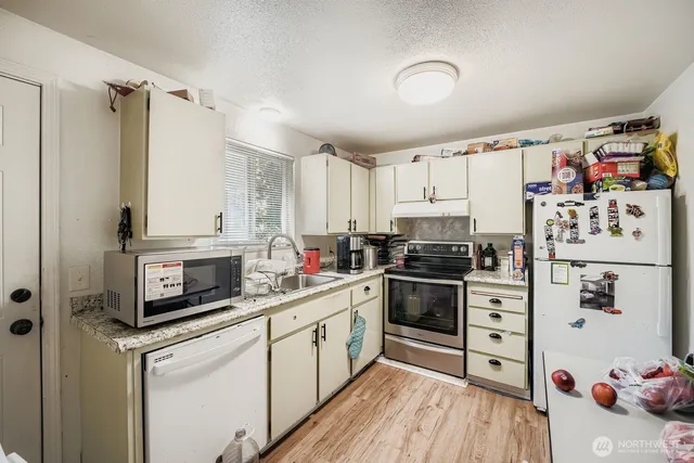 a kitchen with stainless steel appliances a stove a sink and a refrigerator