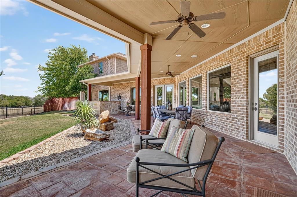 100 Canyon Ridge Trail Aledo, TX 76008 - Photo 33 of 38 Expansive covered patio featuring stamped concrete flooring, brick exterior, multiple ceiling fans, recessed lighting, and large windows