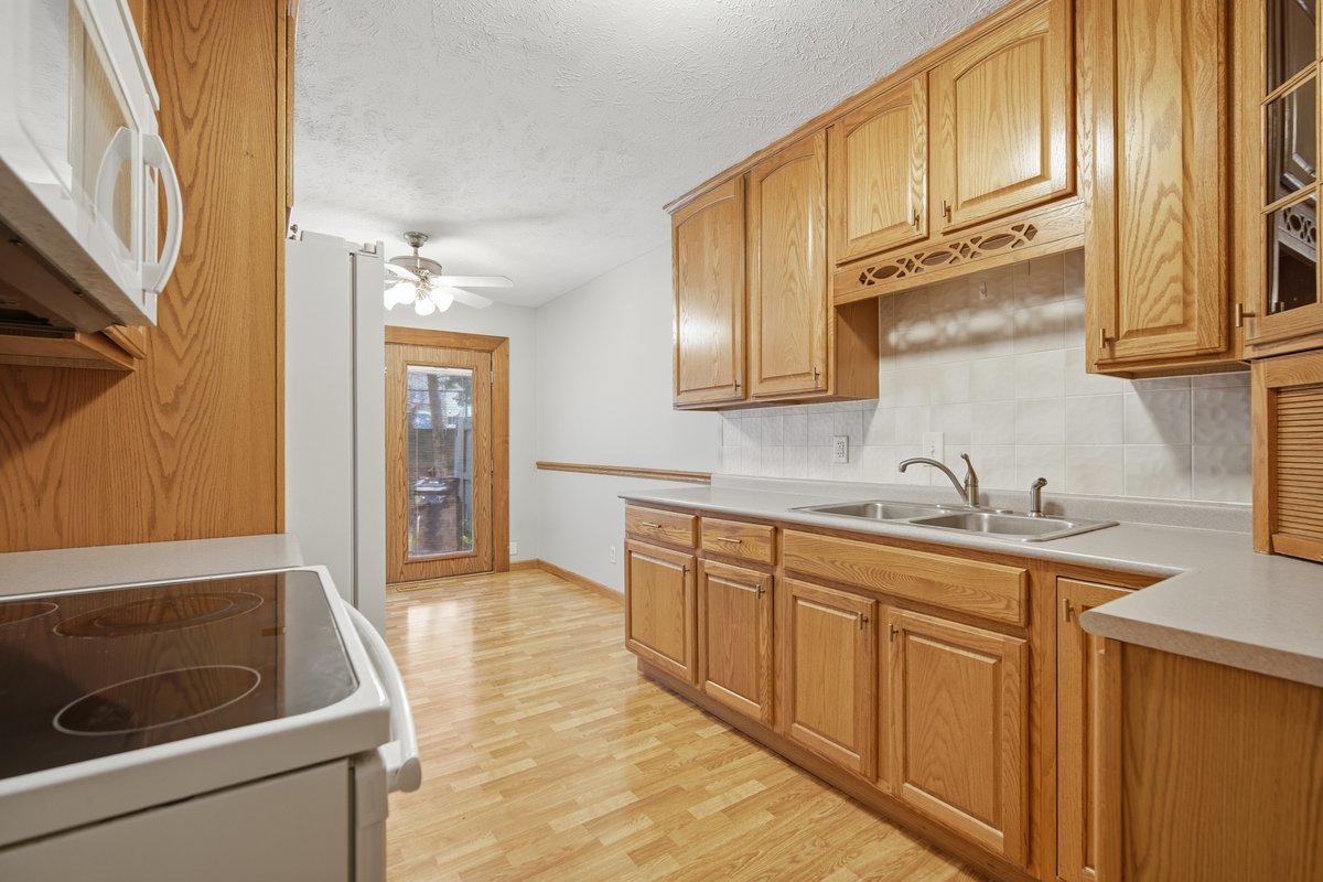 1532 Hunt Drive, Unit A Normal, IL 61761 - Photo 8 of 25 a kitchen with stainless steel appliances granite countertop a sink and dishwasher a stove with wooden cabinets