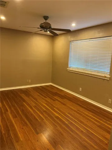 an empty room with a wooden floor and windows