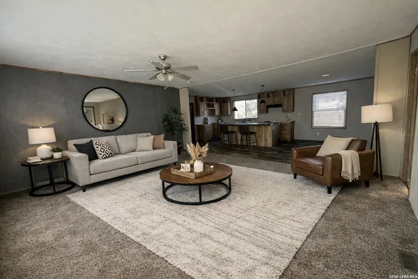 a living room with furniture a large window and a potted plant