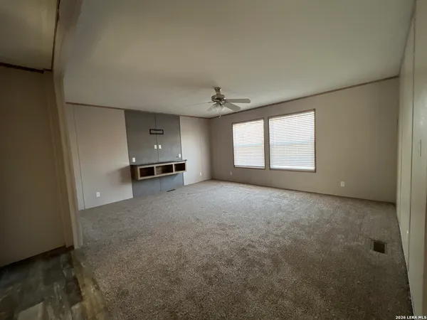 an empty room with a window and a kitchen
