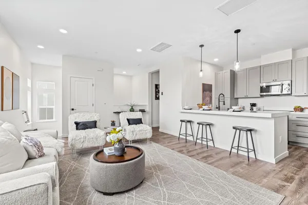 a living room with kitchen a patio and a dining table with kitchen view