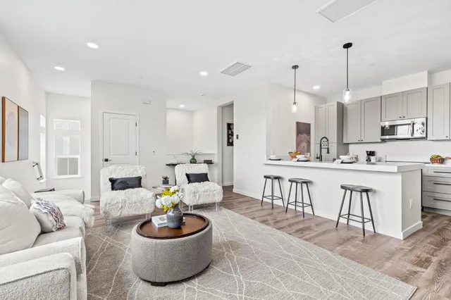 a living room with kitchen a patio and a dining table with kitchen view