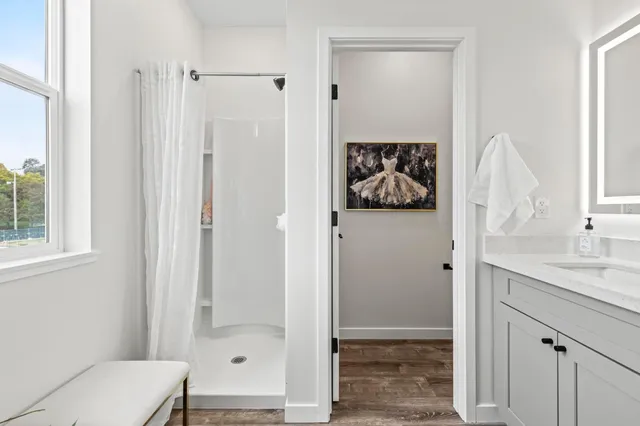 a bathroom with a granite countertop sink a toilet and shower