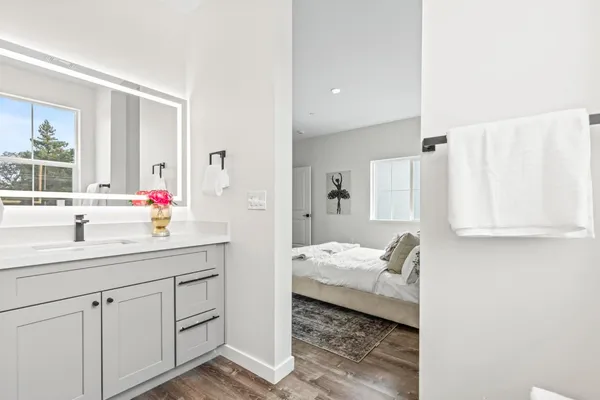 a en suite bathroom with a granite countertop sink and mirror