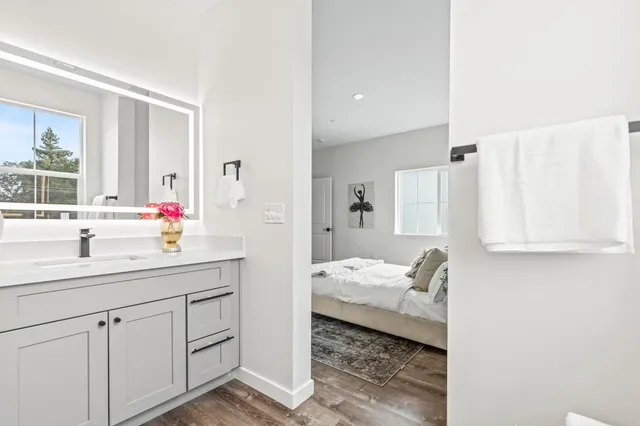 a en suite bathroom with a granite countertop sink and mirror