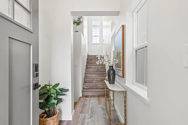 a view of a hallway with wooden floor and a potted plant