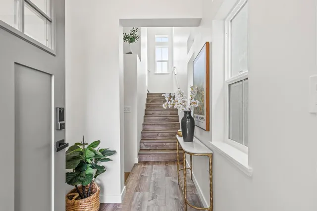 a view of a hallway with wooden floor and a potted plant