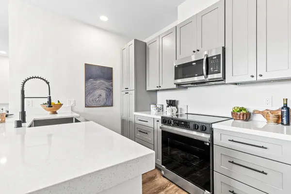 a kitchen with stainless steel appliances granite countertop a stove a sink and a white cabinets