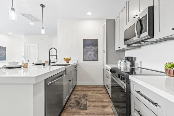 a kitchen with stainless steel appliances a sink stove and cabinets