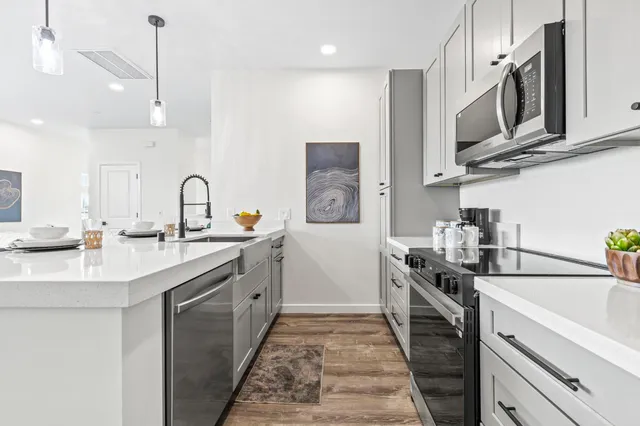 a kitchen with stainless steel appliances a sink stove and cabinets