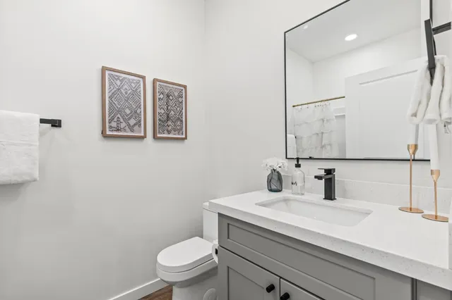 a bathroom with a toilet sink and mirror