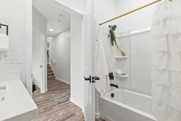 a bathroom with a tub a sink and a shower