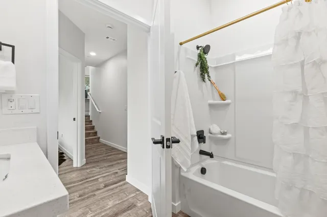 a bathroom with a tub a sink and a shower