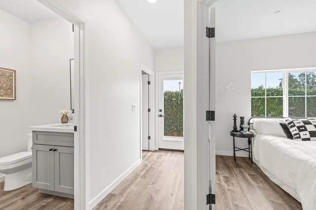 a view of a bedroom with a bed and wooden floor